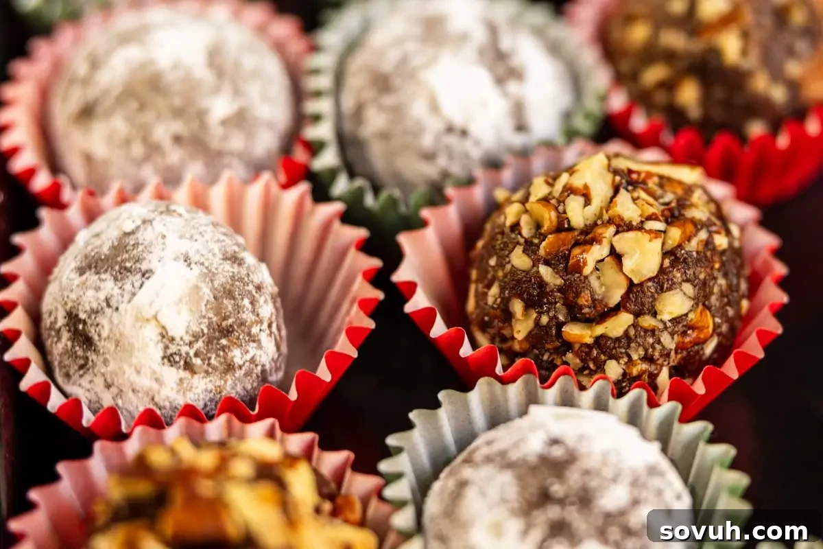 Assorted chocolate truffles in paper wrappers, some coated with powdered sugar and others covered with chopped nuts.