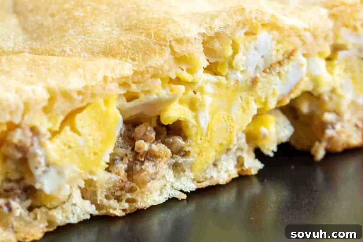 Close-up of a baked breakfast casserole with visible eggs, sausage, and a golden crust.