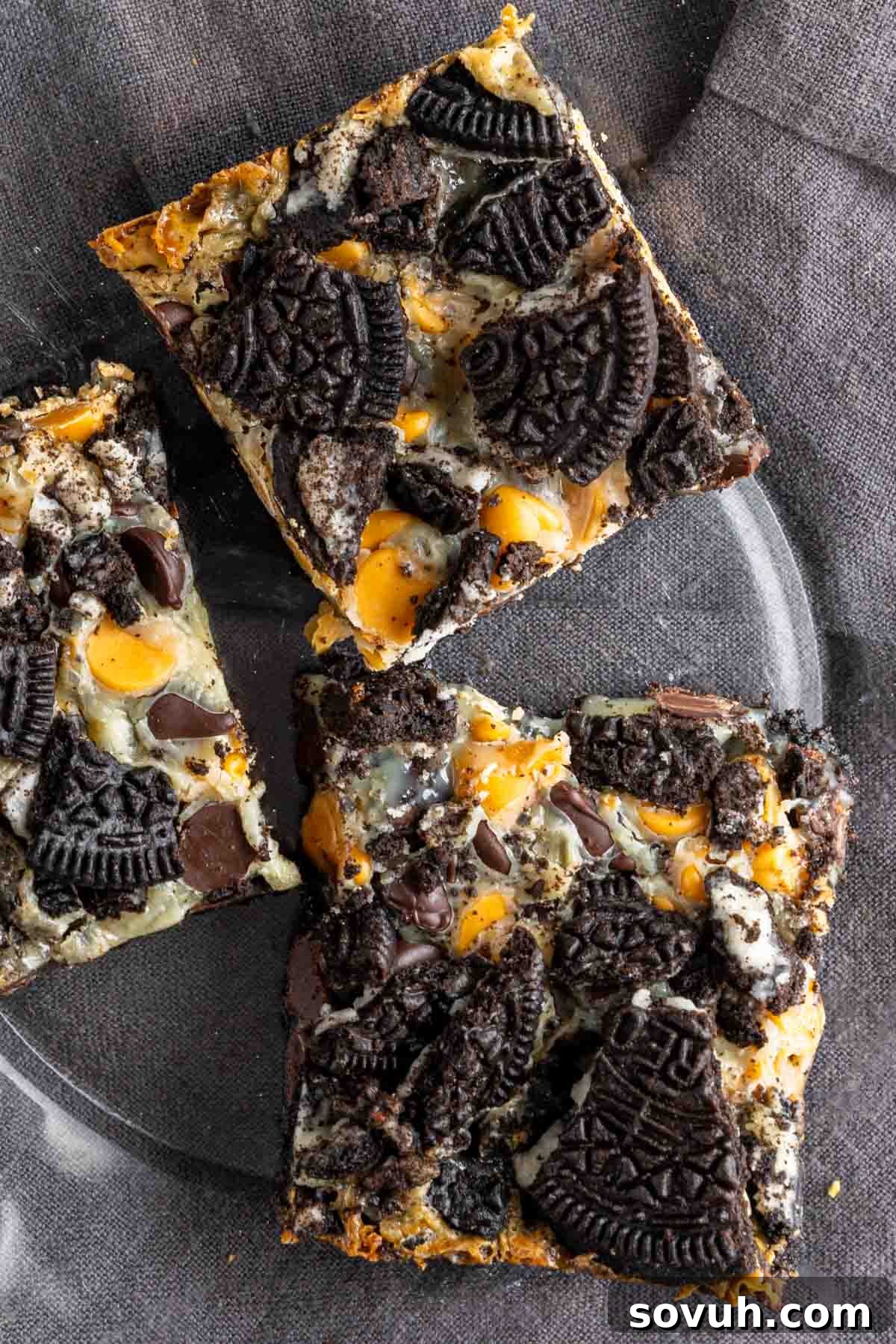 A perfectly cut individual Oreo Magic Bar resting on a clear glass plate, ready to be enjoyed.