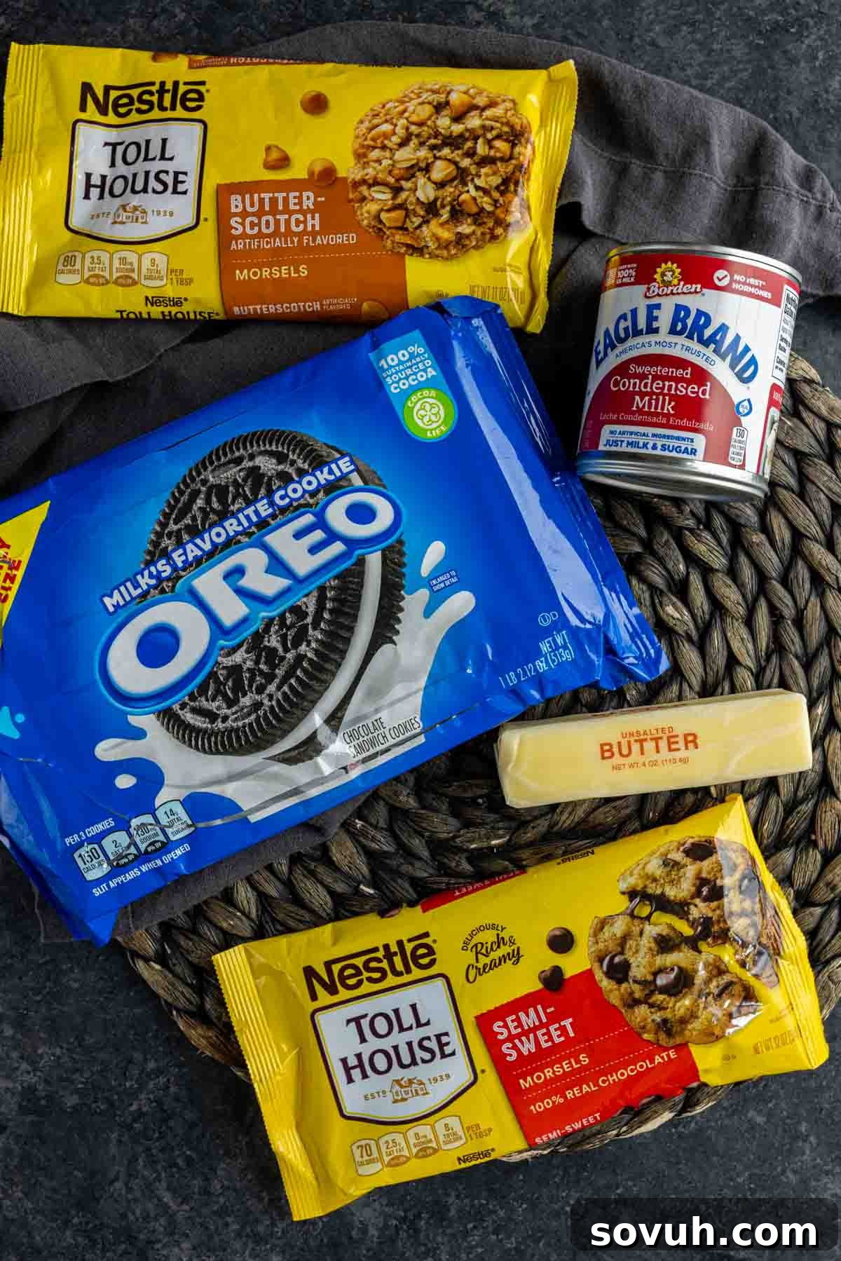 Oreos and various ingredients laid out on a wicker placemat, ready to be transformed into Oreo Magic Bars.