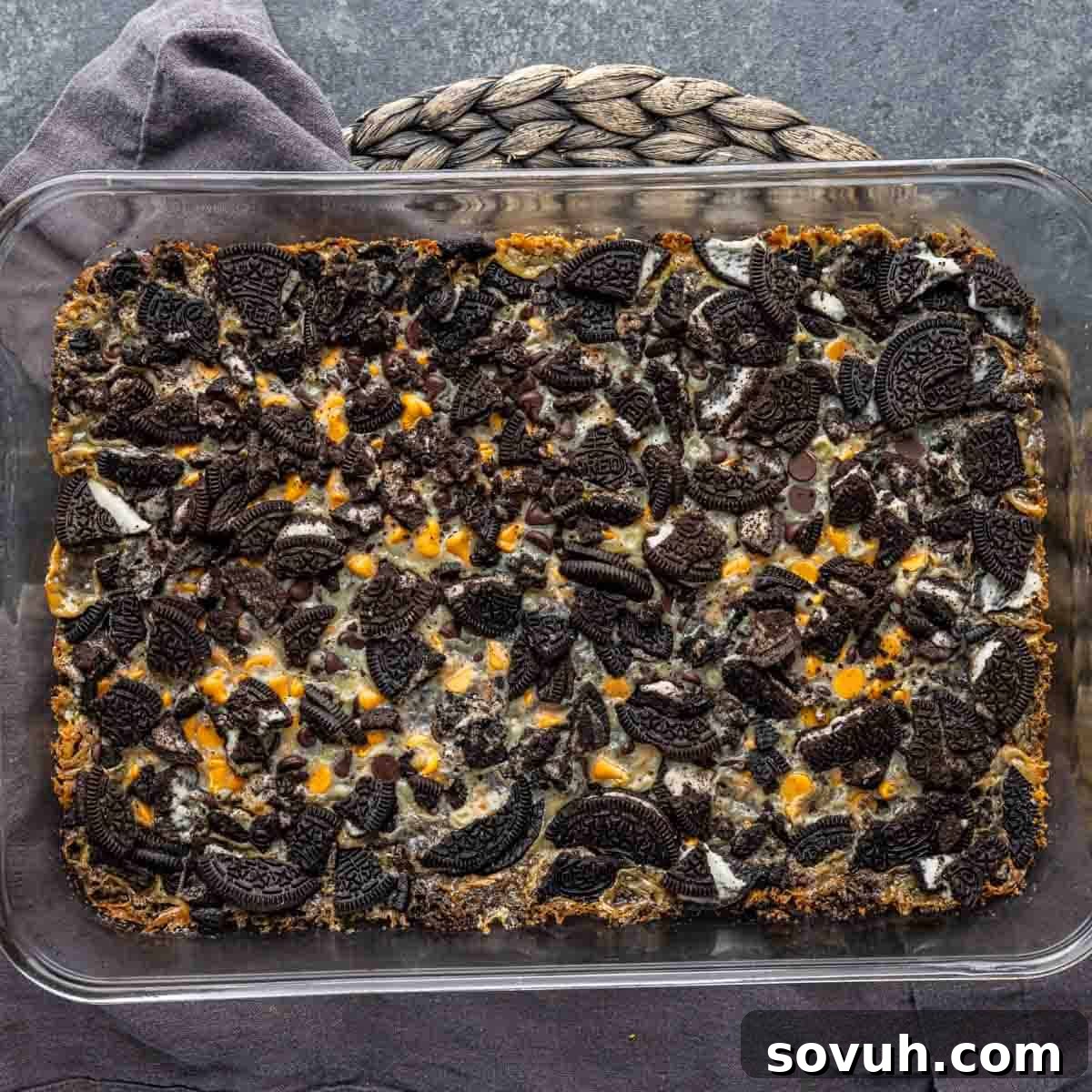 A delectable tray of freshly baked Oreo Magic Bars in a glass baking dish, cooling down and promising a sweet treat.