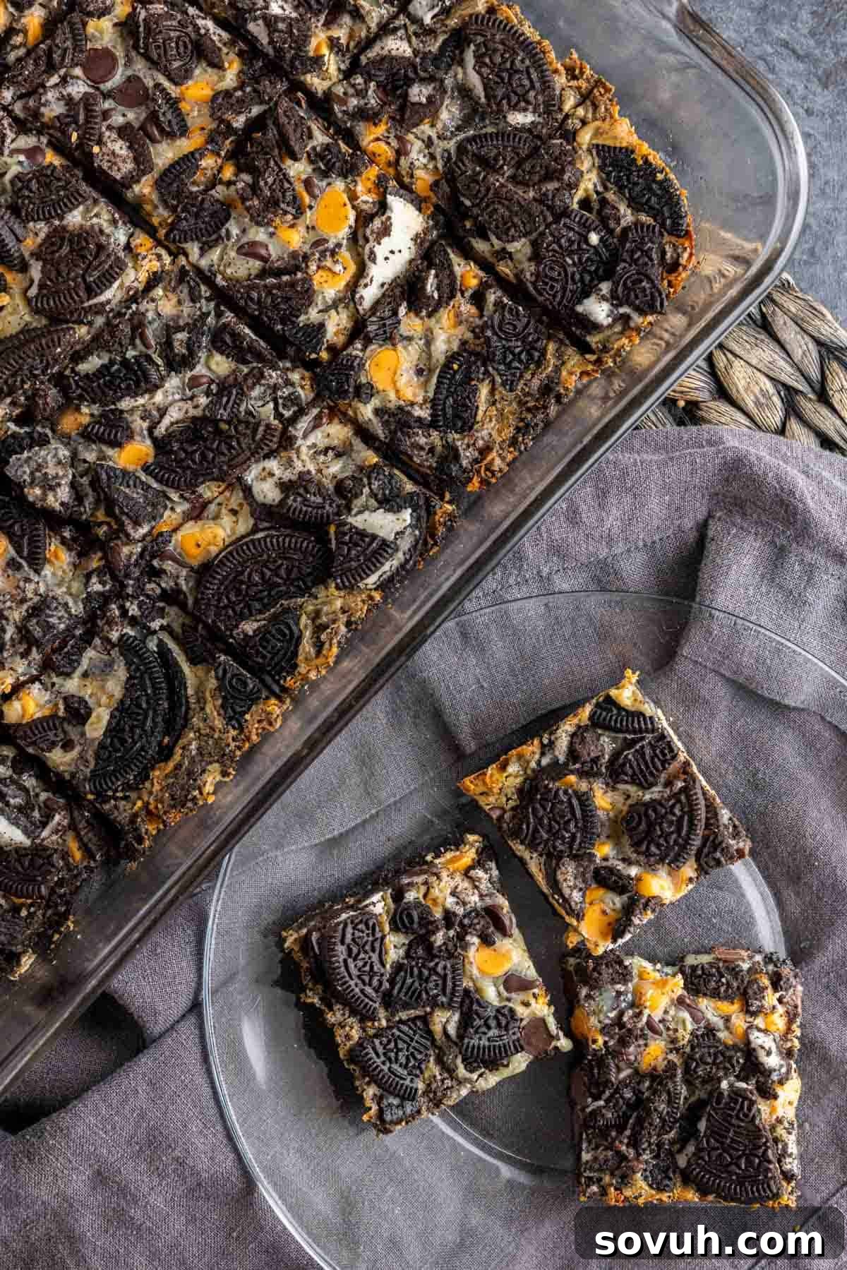 Individual Oreo Magic Bars arranged neatly on a plate with a napkin, showcasing their tempting layers.
