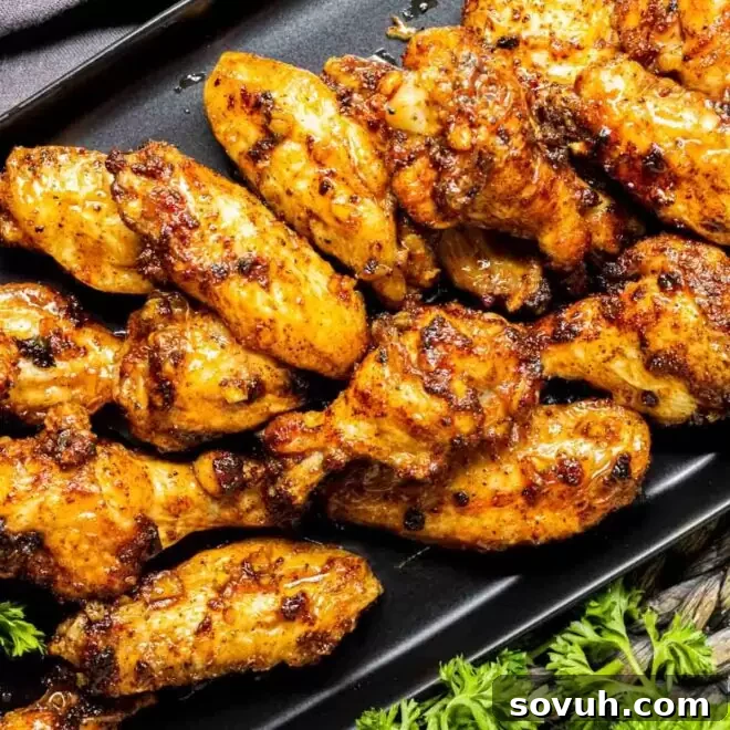 Honey Garlic Chicken Wings on a black plate with parsley.