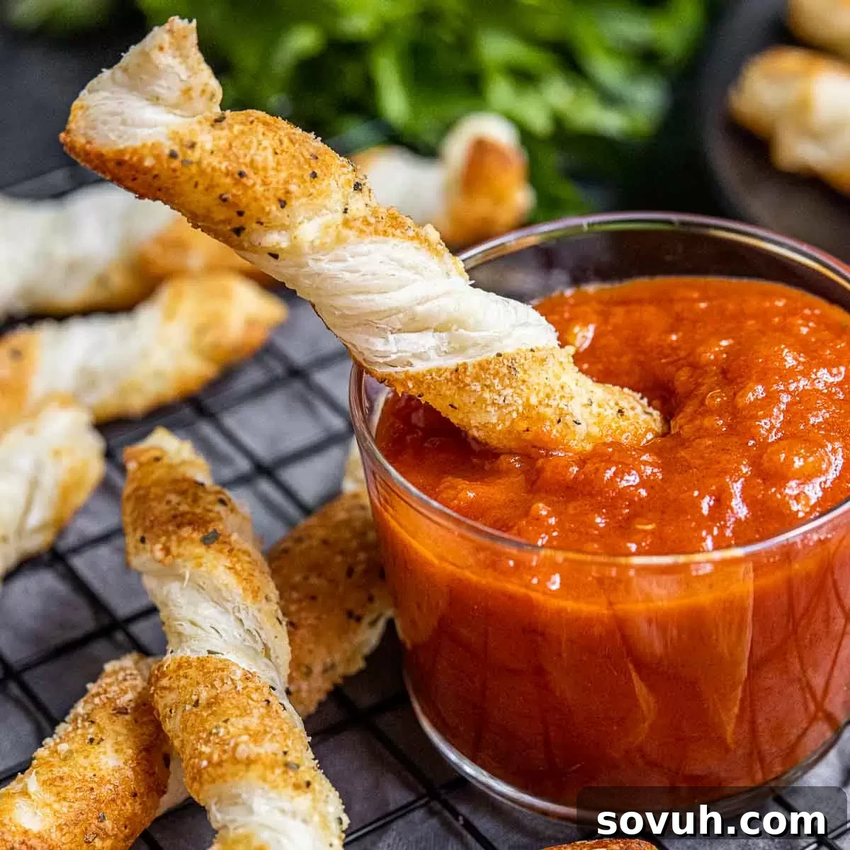 Cheese Twists dipping in sauce, showcasing their golden crispiness and inviting texture.