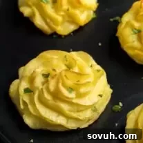 Duchess Potatoes made of piped mashed potatoes, ready for baking.