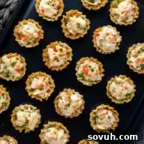A tray of appetizers with cheese and vegetables on it, showcasing the delicious Baked Crab Bites.