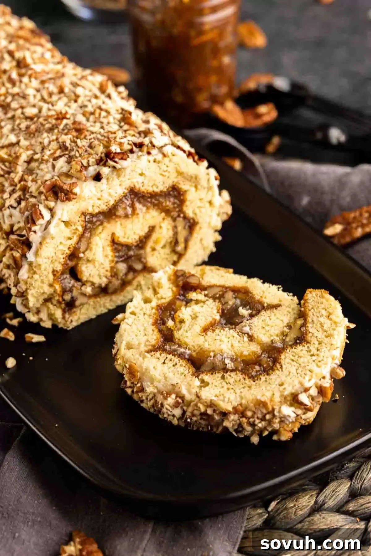 Pecan Pie Cake Roll on a black patter with one slice