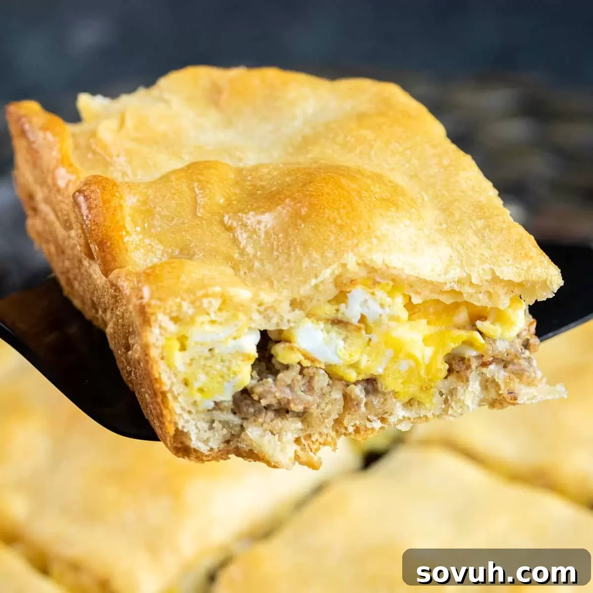 A delectable slice of Eggs and Sausage Crescent Roll Breakfast Casserole, showcasing its layers of ingredients.