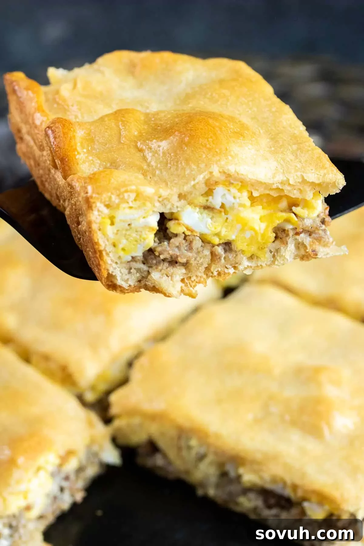 A single piece of Eggs and Sausage Crescent Roll Breakfast Casserole, perfectly baked and ready to eat.