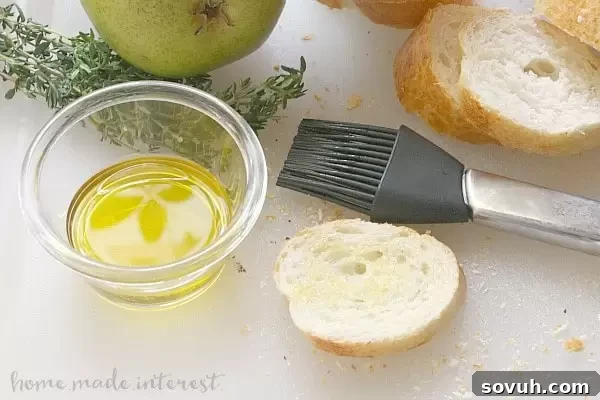 Close-up view of a single Havarti, Ham, and Pear Crostini, highlighting the thinly sliced pear and ham, the soft Havarti, and the golden-brown crostini base.