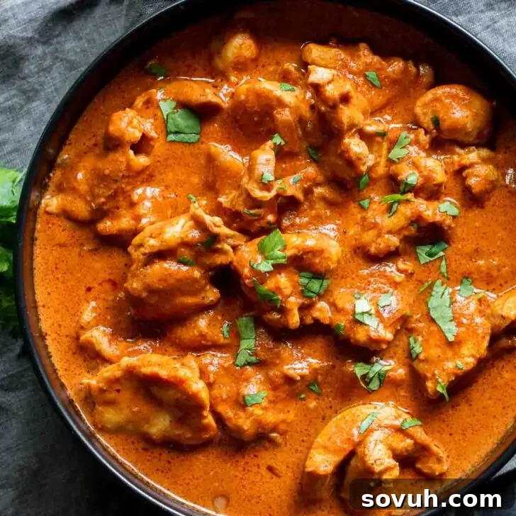 A bowl of Instant Pot Butter Chicken with a rich, creamy sauce and fresh herbs for garnish.
