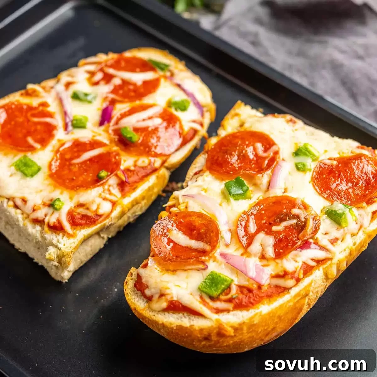 Crispy French Bread Pizza made in the oven, topped with cheese and pepperoni, on a baking sheet.