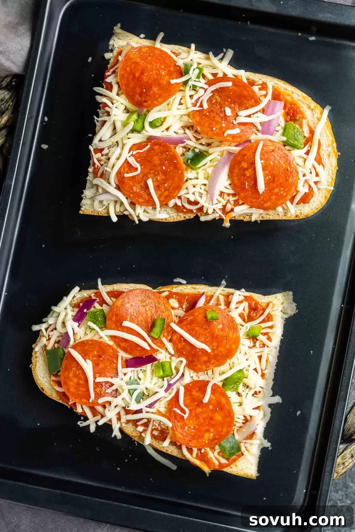 Freshly baked French Bread Pizza on a baking sheet, featuring melted cheese and a crispy crust.