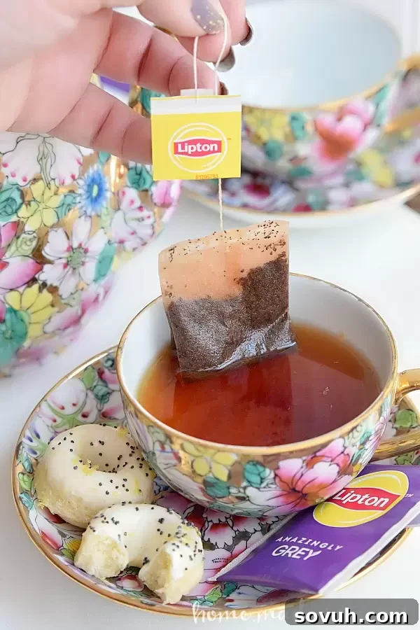 A Lipton tea bag steeping in a cup, symbolizing a peaceful break with homemade mini donuts.