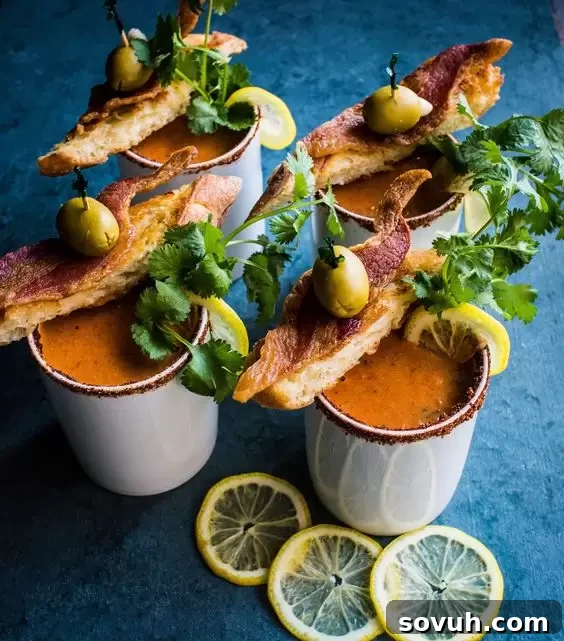 A comforting bowl of Bloody Mary Soup, garnished with fresh herbs and a slice of lemon.
