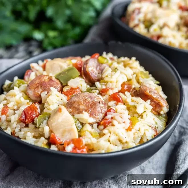 A steaming bowl of Instant Pot Jambalaya, showcasing rice, chicken, and Andouille sausage with a rich, spicy tomato base.