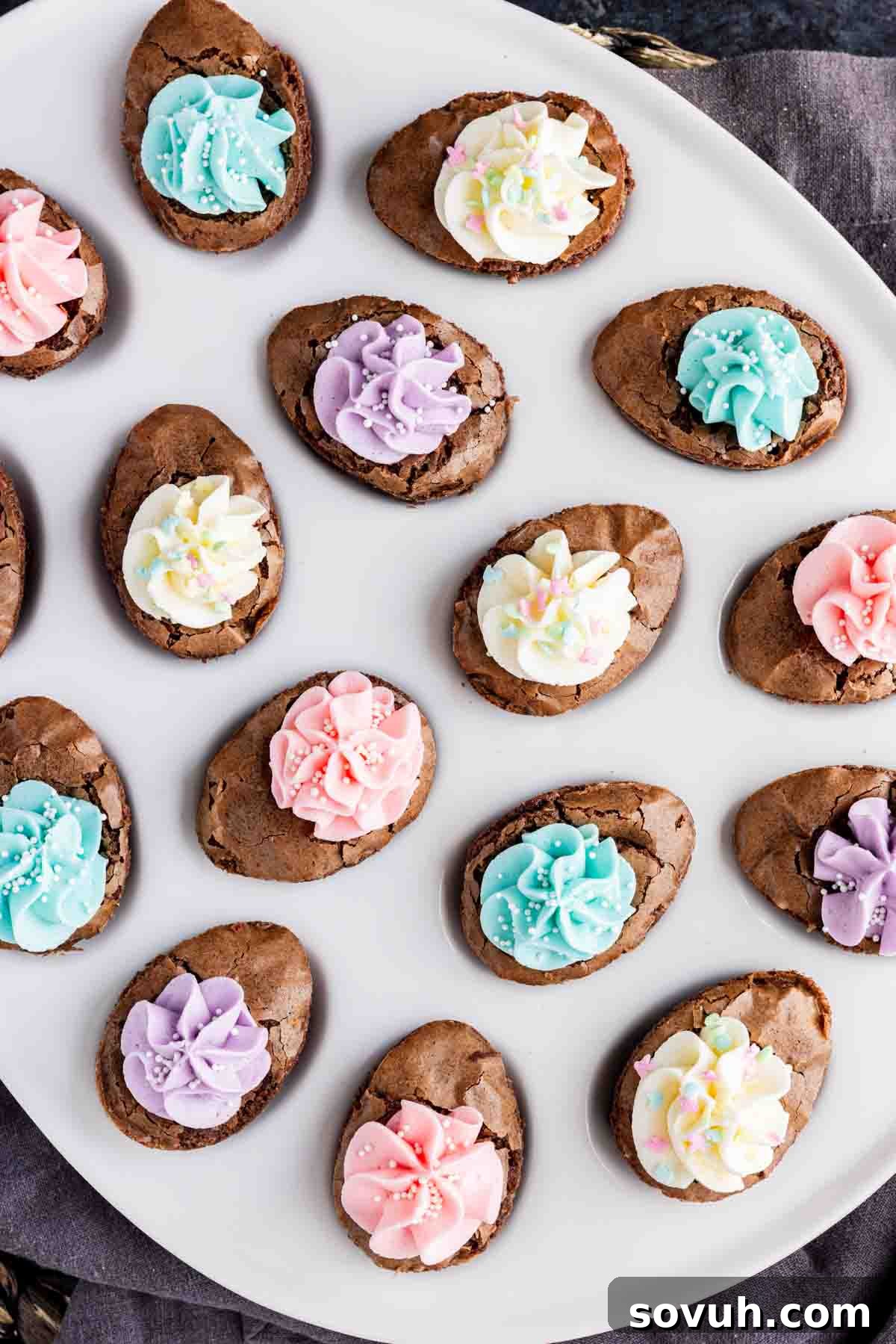 Devilish Easter Brownies from a Box 7 A plate of oval-shaped chocolate cookies topped with colorful pastel icing in pink, blue, purple, and white makes an easy Easter dessert, perfect for celebrating the season.