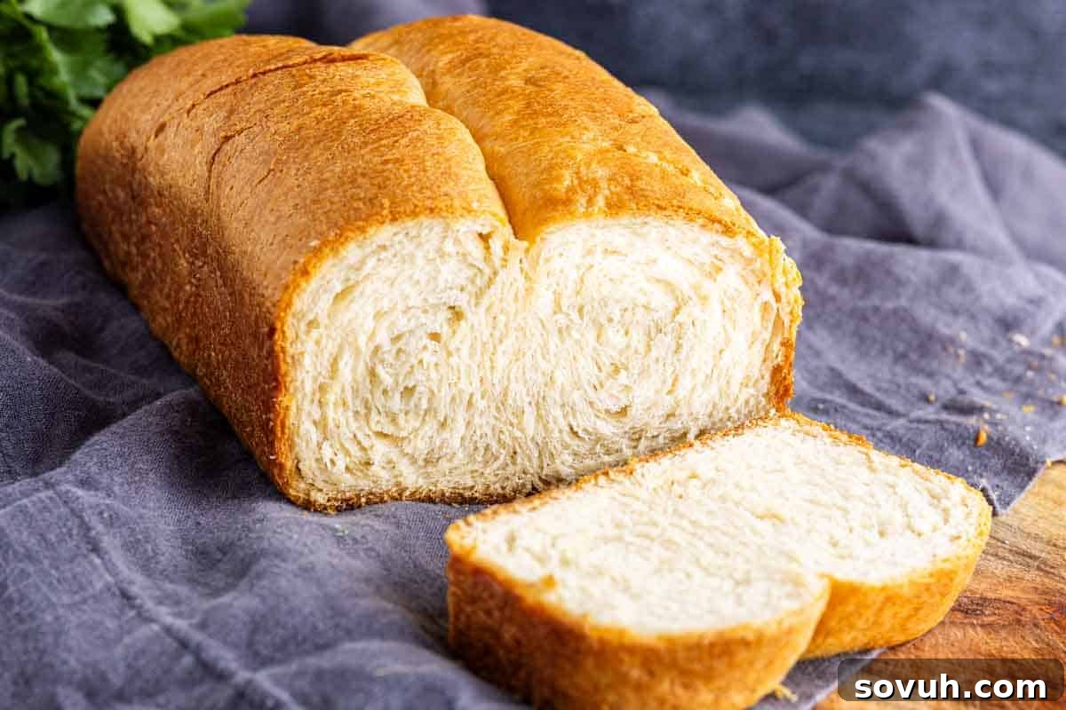 The Viral Golden Crescent Bake 2 A buttery bread loaf, with two slices cut from it, rests on a cloth and wooden surface—perfect for trying out your latest TikTok bread hack. The golden crust hints at its delicious, flaky interior.