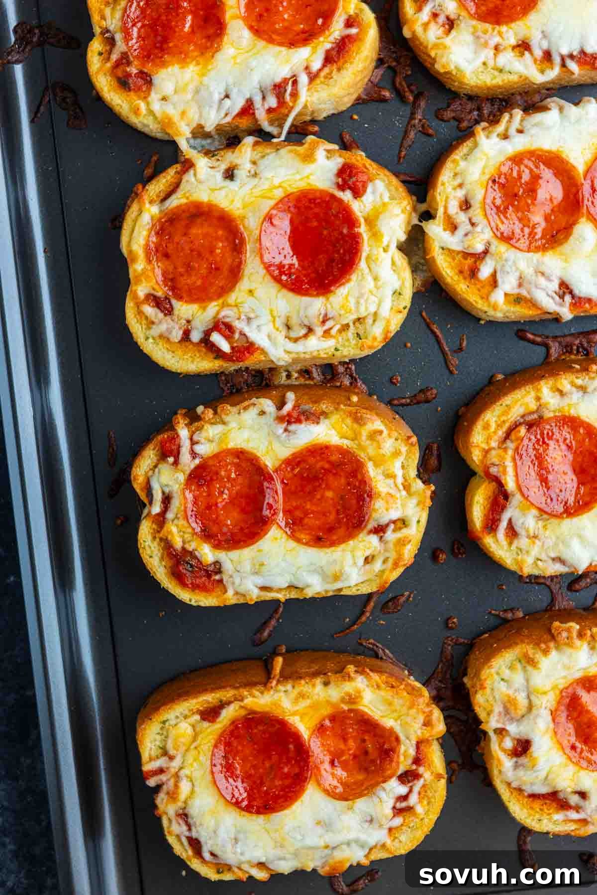 15-Minute Texas Toast Pizza Recipe for Quick Family Dinner 6 Slices of toasted bread topped with melted cheese, pepperoni, and tomato sauce arranged on a baking sheet—a classic Texas Toast Pizza that's an easy pizza toast recipe for quick weeknight meals.