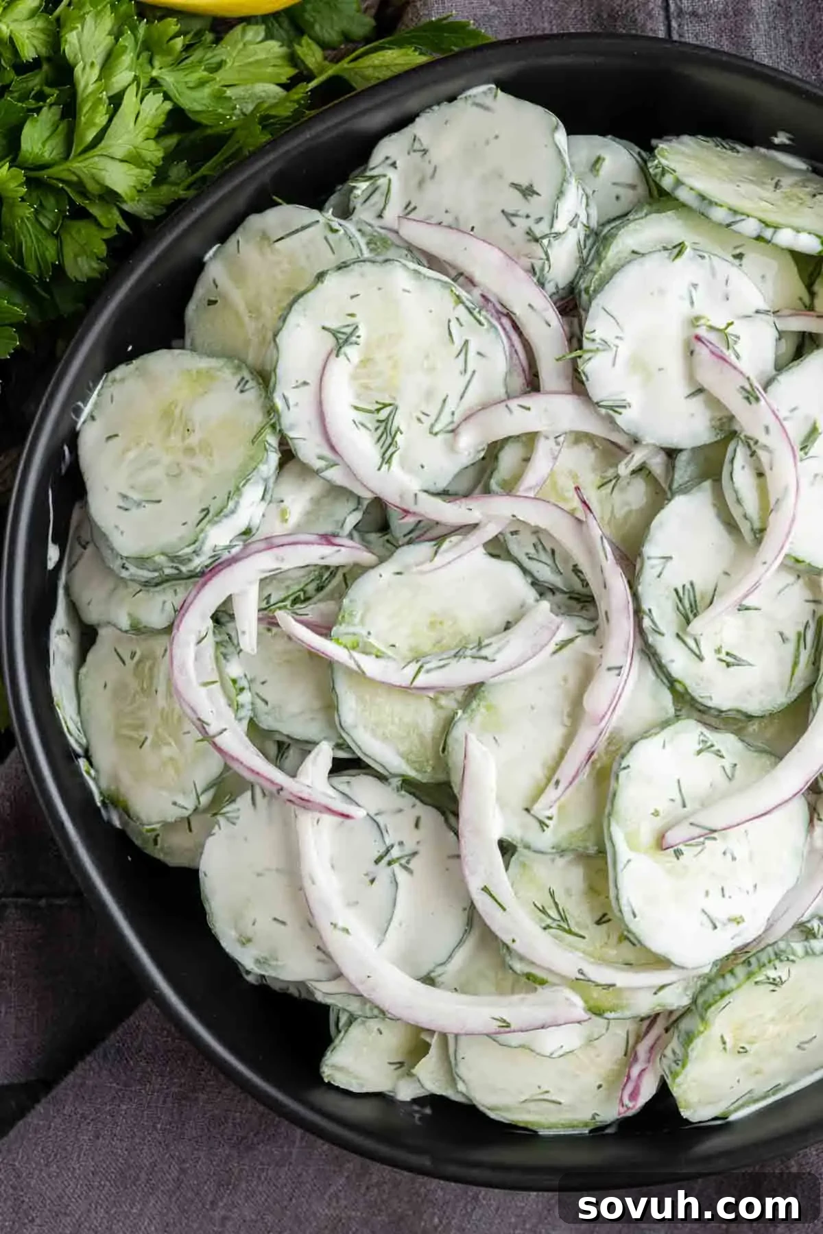 Creamy Summer Cucumber Salad with Dill and Yogurt 8 A bowl of creamy cucumber salad with sliced cucumbers, red onions, and a rich dill dressing.