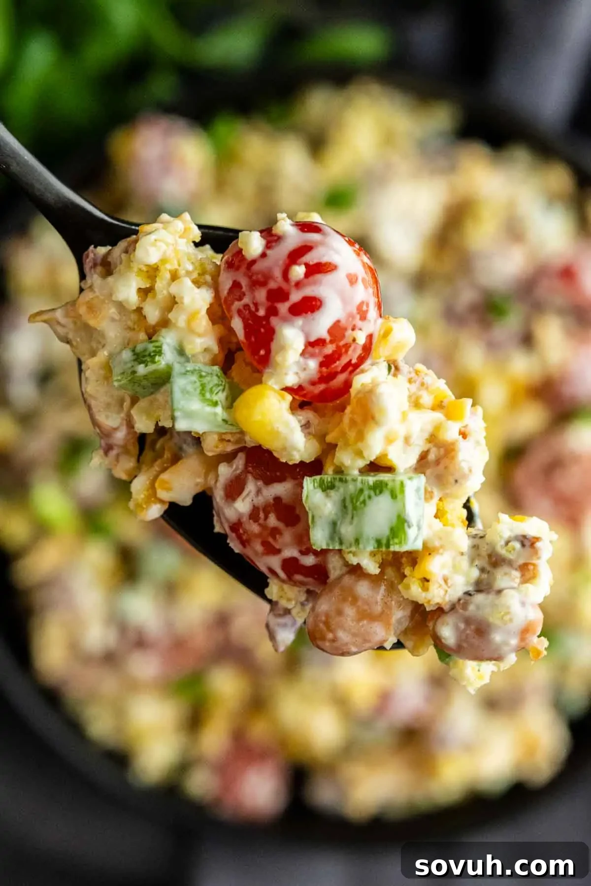 Southern Cornbread Salad Recipe for Potlucks and BBQs 6 A close-up of a spoonful of creamy salad with cherry tomatoes, corn, green peppers, beans, and cheese—perfect as a Southern potluck side dish or for your next summer BBQ side.
