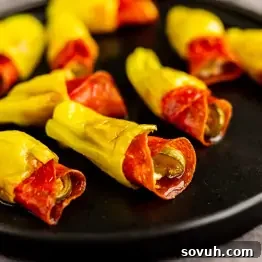 Air Fryer Stuffed Pepperoncinis with Pepperoni and Hot Honey 9 Several yellow banana peppers, also known as pepperoni stuffed pepperoncinis, are filled with slices of pepperoni and arranged on a black plate.