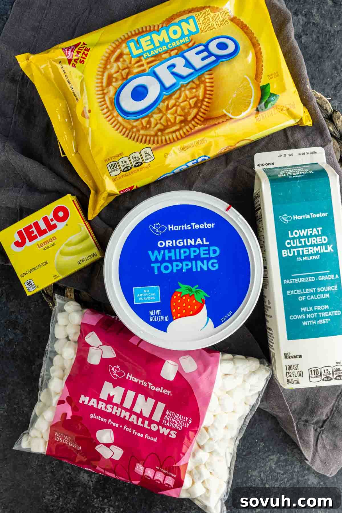 Lemon Cookie Salad: Bright Midwestern Dessert Twist 3 A carton of buttermilk, whipped topping, mini marshmallows, lemon Jello mix, and lemon Oreos are arranged on a dark surface—perfect for making a refreshing lemon fluff or your favorite lemon cookie salad recipe.